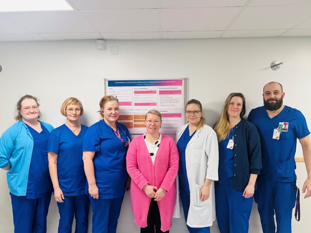 Kuvateksti: Hotuksen Näytöllä tuloksiin -kilpailun 2026 voitti Pirkanmaan hyvinvointialueen Tampereen yliopistollisessa sairaalassa toimiva neurologian vuodeosasto. Kuvassa vasemmalta lähtien apulaisosastonhoitaja Essi Kokko, fysioterapeutti Sari Heinonen, osastonhoitaja Katri Ketola, tutkimushoitaja ja kehittämistyön vetäjä Laura Nevaharju-Sarantis, neurologi Emilia Lilja, sairaanhoitaja Laura Vaesoja ja farmaseutti Aleksi Heinonen. Kuvasta puuttuvat projektiryhmän jäsenistä fysioterapeutti Päivi Kotioja-Närvänen ja sairaanhoitaja Heli Palukka. Kuva: Onni Leinonen.